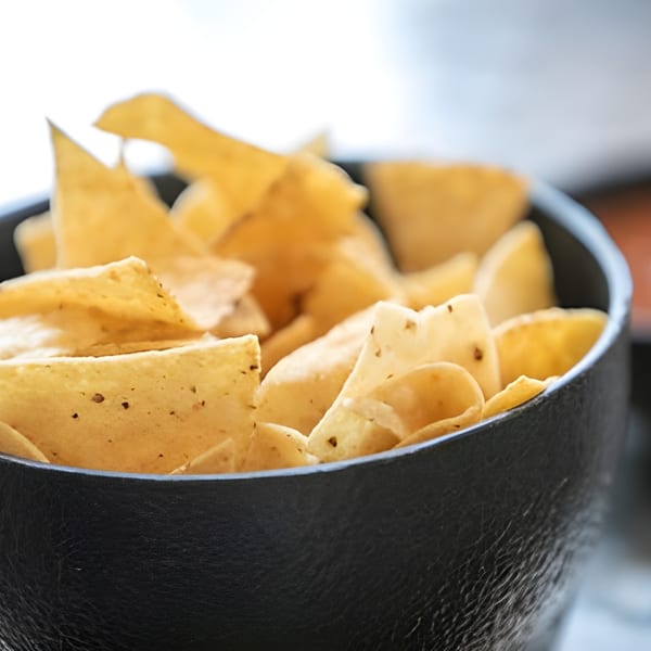 Close-up of a black bowl filled with crispy, seasoned tortilla chips from Habanero's Fresh Mex.